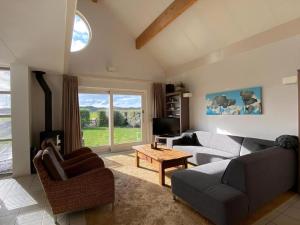 een woonkamer met een bank, stoelen en een tv bij Luxusvilla Ooghduyne Mit Privatem Whirlpool in Julianadorp