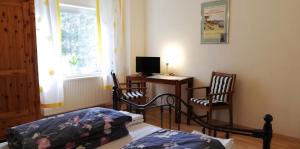 Un dormitorio con una cama y un escritorio con una computadora. en Appartement In Ruhbank Mit Garten Und Terrasse, en Pirmasens