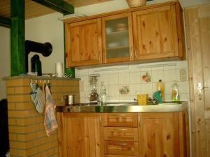 a kitchen with a sink and wooden cabinets at Ferienhaus In Neustadt Harz Mit Terrasse, Grill Und Garten in Harztor