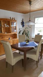 a dining room with a wooden table and chairs at Daisy 78 in Wilhelmshaven
