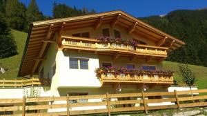 a house with a balcony with flowers on it at Ferienwohnung In Brandberg Mit Garten in Mayrhofen