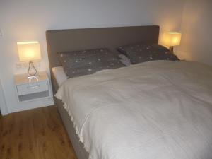 a bedroom with a white bed and two lamps at Luxus Appartement In Kappel in Lenzkirch