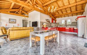 una cucina con armadi rossi e tavolo bianco di Cozy Home In Gardonne With Wifi a Gardonne