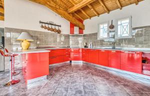 una cucina con armadi rossi e soffitto in legno di Cozy Home In Gardonne With Wifi a Gardonne