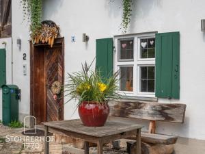 a vase on a wooden table in front of a building at Wunderschönes Ferienhaus Mit Kamin In Riederau in Dießen am Ammersee