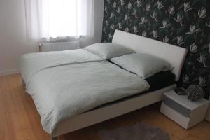 Ce lit se trouve dans une chambre dotée d'un papier peint noir et blanc. dans l'établissement Küsterhaus, à Butjadingen