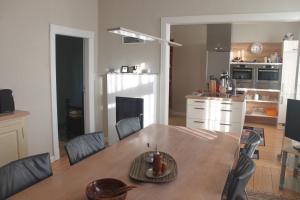 une cuisine et une salle à manger avec une table et des chaises dans l'établissement Küsterhaus, à Butjadingen