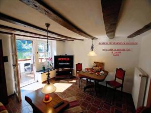 Una sala de estar con una mesa y un televisor. en Altes Fährhaus Anno 1 6 3 3 Traumferienwohnung In Exponierter Moselufer Lage, en Traben-Trarbach