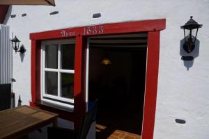 Un edificio rojo y blanco con una ventana y una mesa. en Altes Fährhaus Anno 1 6 3 3 Traumferienwohnung In Exponierter Moselufer Lage, en Traben-Trarbach 32 fotos más