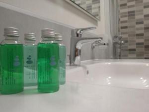 three green bottles sitting on top of a bathroom sink at Schöne Wohnung Mit Sonnenterrasse Und Meerblick in Morro del Jable +16 photos