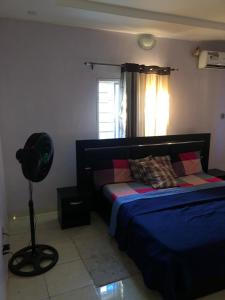 a bedroom with a bed and a fan next to a window at 3 Bedroom Bungalow at Heliu Estate in Enugu