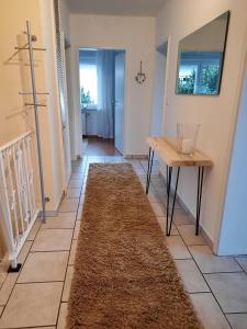 a hallway with a table and a rug on the floor at Ferienwohnung Idyll Mit Loggia Und Garten in Welferode +12 photos