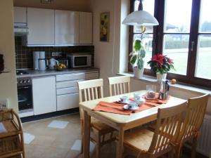 a kitchen with a wooden table with chairs and a dining room at Apartment Bergblick in Abtenau