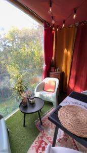 a room with a bed and a large window at LAmOuR in Oudon +4 photos
