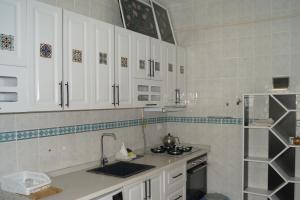 a kitchen with white cabinets and a sink at Hibe Dede Konak in Ürgüp