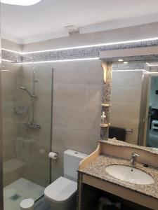 W łazience znajduje się toaleta, umywalka i lustro. w obiekcie Ruhige Ferienwohnung Für 4 Personen w Costa Teguise