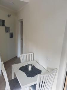 Biały stół z dwoma krzesłami i świecą w obiekcie Ruhige Ferienwohnung Für 4 Personen w Costa Teguise +4 zdjęcia