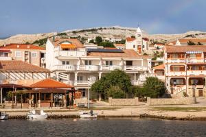 a group of buildings next to a body of water at Appartement Rajka in Kustići