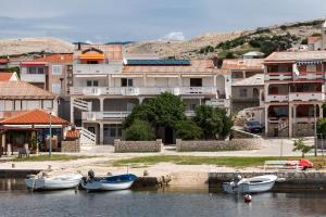 a group of boats docked in the water next to buildings at Appartement Rajka in Kustići