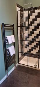 a bathroom with a shower with towels and a mirror at Crescent House in Plymouth +62 photos