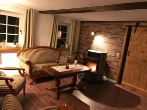 un salon avec une table et une cheminée dans l'établissement Gemütliches Reetdachhaus In Schleswig Holstein, à Neuendorf-Sachsenbande