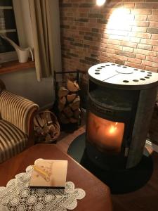 d'un salon avec une cheminée et une table. dans l'établissement Gemütliches Reetdachhaus In Schleswig Holstein, à Neuendorf-Sachsenbande 14 autres photos