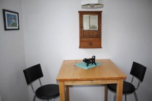 a wooden table with chairs and a toy dog on a towel at Wohnung In Gießelrade Mit Großem Garten in Ahrensbök