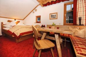 a bedroom with a bed and a wooden table and chair at Ruhiges Appartement In St Gallenkirch in Sankt Gallenkirch