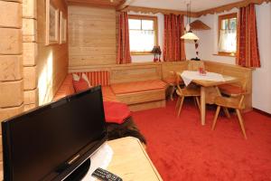 a living room with a flat screen tv and a table at Ruhige Wohnung In Sankt Gallenkirch Mit Garten in Sankt Gallenkirch