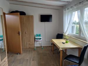 a small room with a desk and a table and a chair at Nette Wohnung In Großsteinberg Mit Grill Und Terrasse in Pomssen