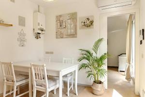 una sala da pranzo bianca con tavolo e sedie bianchi di Villa Glicini a Ostra