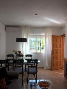 a living room with a table and chairs and a window at Schönes Ferienhaus Mit Pool Und Terrasse in Los Urrutias +32 photos