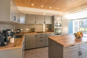 a kitchen with white cabinets and a wooden ceiling at Haus Am Yachthafen in Ostseebad Karlshagen