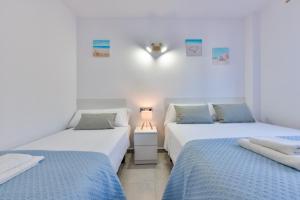 two beds in a white room with a lamp between them at Villas Guzman - Paraiso Mar in Calpe +31 photos