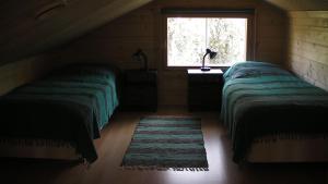 zwei Betten in einem Zimmer mit Fenster in der Unterkunft Ferienhaus für 5 Personen ca 62 m in Rauhala, Finnisch-Lappland Pallas-Yllästunturi-Nationalpark in Rauhala