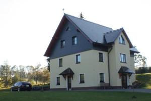 a large white house with a black roof at Fewo Erzgebirge in Dorfchemnitz