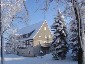 a large building with a snow covered christmas tree at Fewo Erzgebirge in Dorfchemnitz +10 photos