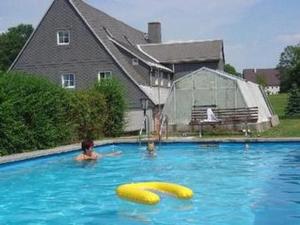a boy in a swimming pool with two yellow inflatable objects at Fewo Erzgebirge in Dorfchemnitz