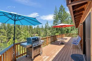 a deck with a grill and a table and umbrella at The Big Easy Lakefront Cabin in Groveland