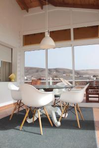 a dining room with white chairs and a table with a view at Großes Modernes Ferienapartment Villa Atlantico in La Pared