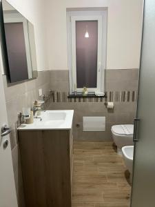 a bathroom with a sink and a toilet and a window at 500 Pit-Stop B&B - Milazzo in Milazzo +16 photos