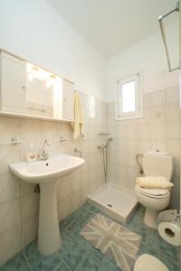 Un baño blanco con lavabo e inodoro. en Penny's Studios, en Agia Efimia