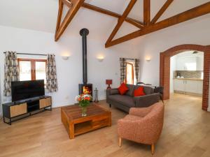 a living room with a couch and a fireplace at Woodland Roost in Bideford