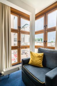 a living room with a couch and large windows at Familienapartment nahe der Frauenkirche in Dresden