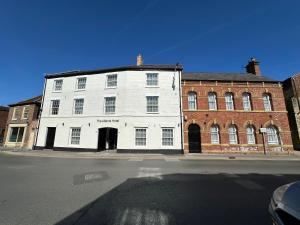 a white building on the corner of a street at The Abbots Boutique Hotel in Selby