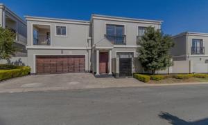 a large white house with a garage at La Vida Luxe in Fourways +5 photos