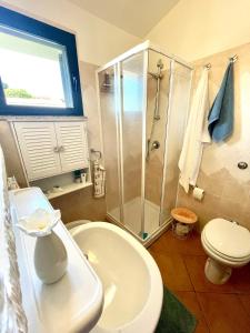 a bathroom with a shower and a toilet and a sink at Appartamento Sunshine in Badesi