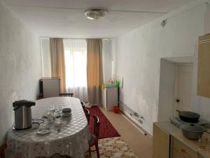 a kitchen with a table in a room at Jakesh in Karakol