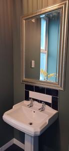 Un baño con un lavabo blanco y un espejo. en Crescent House, en Plymouth 43 fotos más