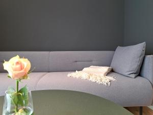 a purple couch with a flower on a table at Eck am Meer 1 - Barrierefreies Apartment in Eckernförde